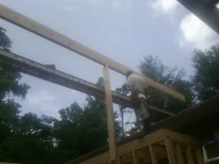Carpenter setting a ridge beam over a new addition frame — Ice Dam Removal by Roofing Brothers in Alcoa