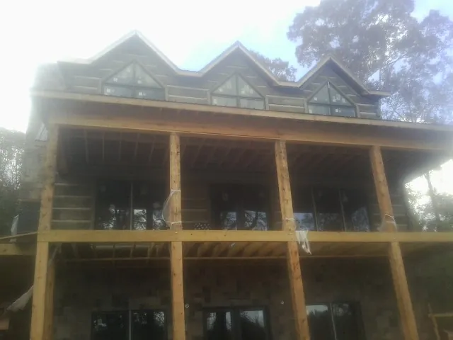 Dormers and porch framing on a large log home under construction — Roof Coating work by our crew in Alcoa